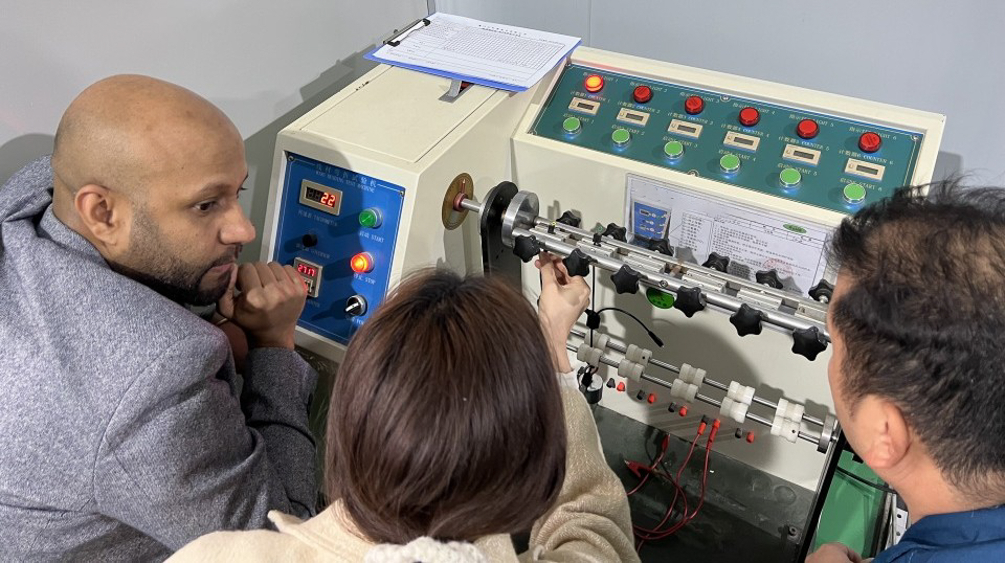 BRIGHT Products Technical Engineer Mohammed Yassin (left) joins BRIGHT’s manufacturing partners in observing a wire‑bending test that is part of the engineering stress tests the company carries out to ensure the quality and reliability of its products.