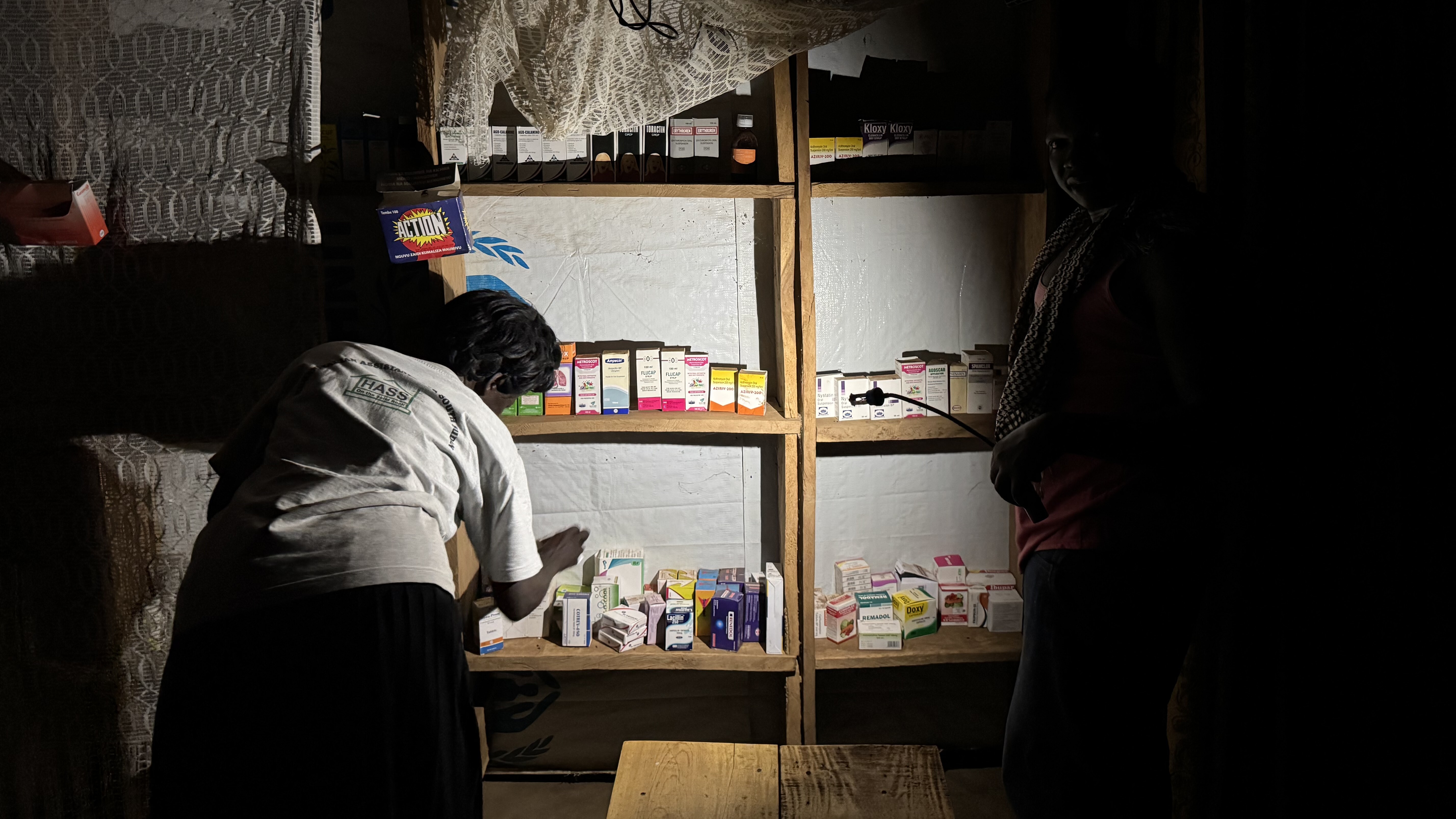 Impact of BRIGHT's Repair Program: Repaired solar lamps enabled businesses like this pharmacy to serve the community after dark, improving access to essential services. (© IOM)