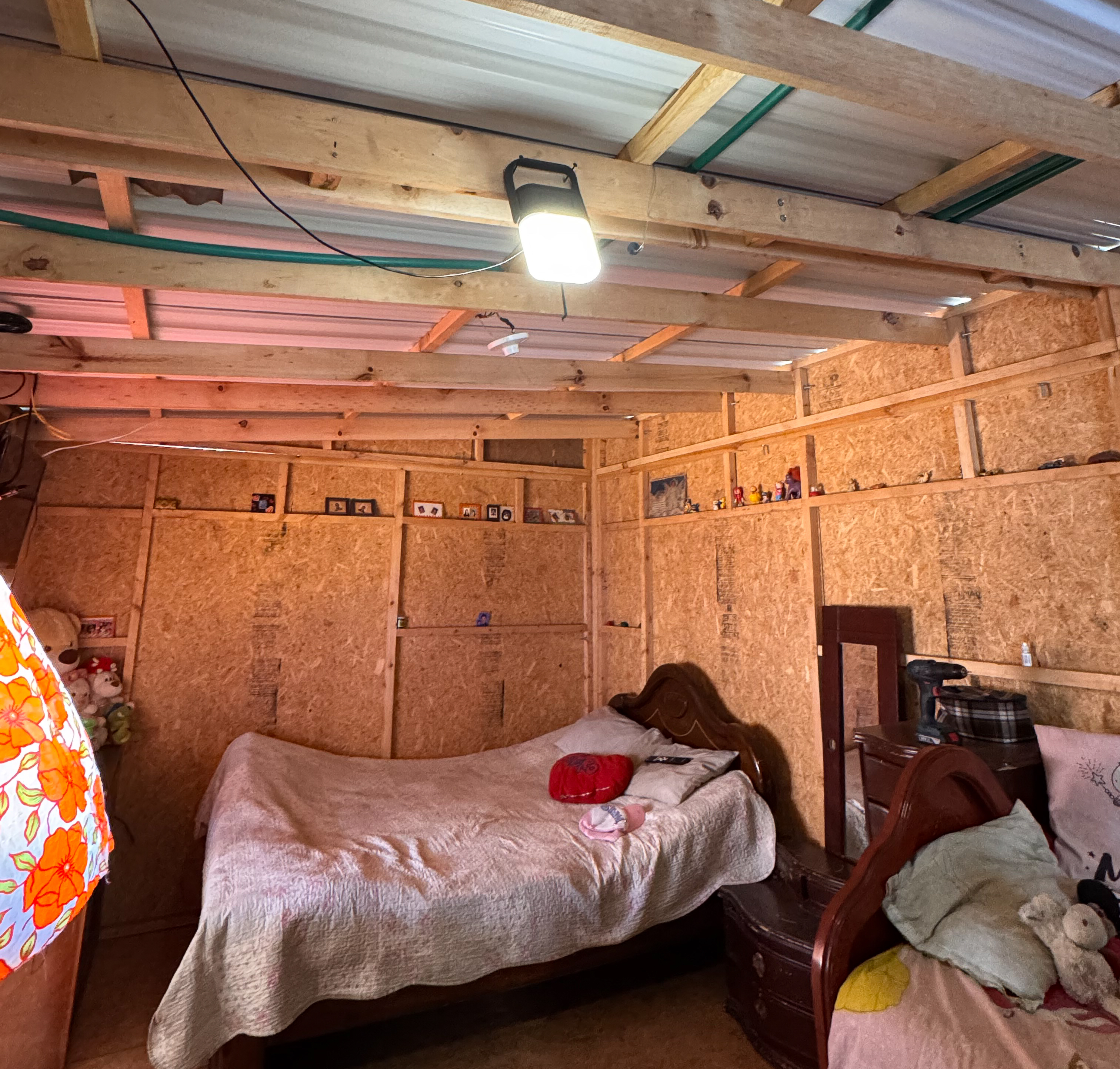 A Sol Mid Capacity solar lamp fixed inside a TECHO shelter, illuminating the space with 360-degree light using its swivel handle mount.