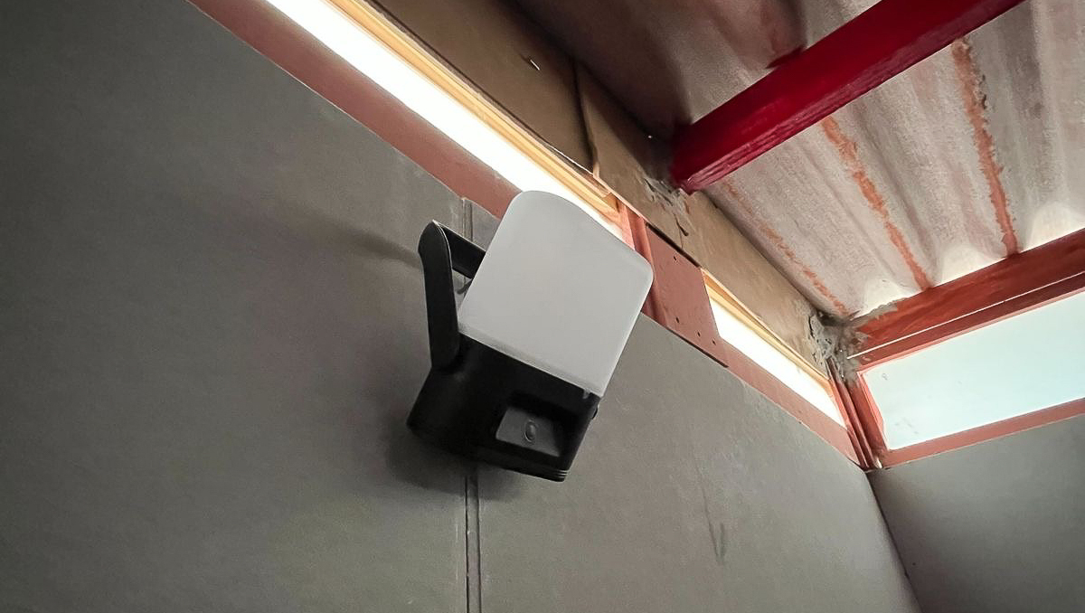 A Sol High Capacity solar lamp fixed to a wall using its swivel handle inside a TECHO shelter in Mexico, providing indoor lighting.